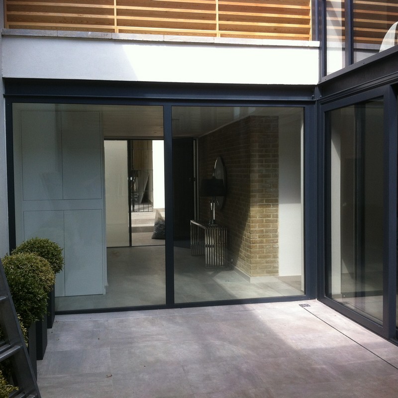 Floor-to-ceiling sliding doors opening to courtyard in Plaistow