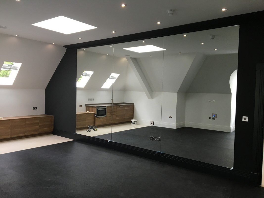 Frameless glass wall dividing loft conversion in Plaistow